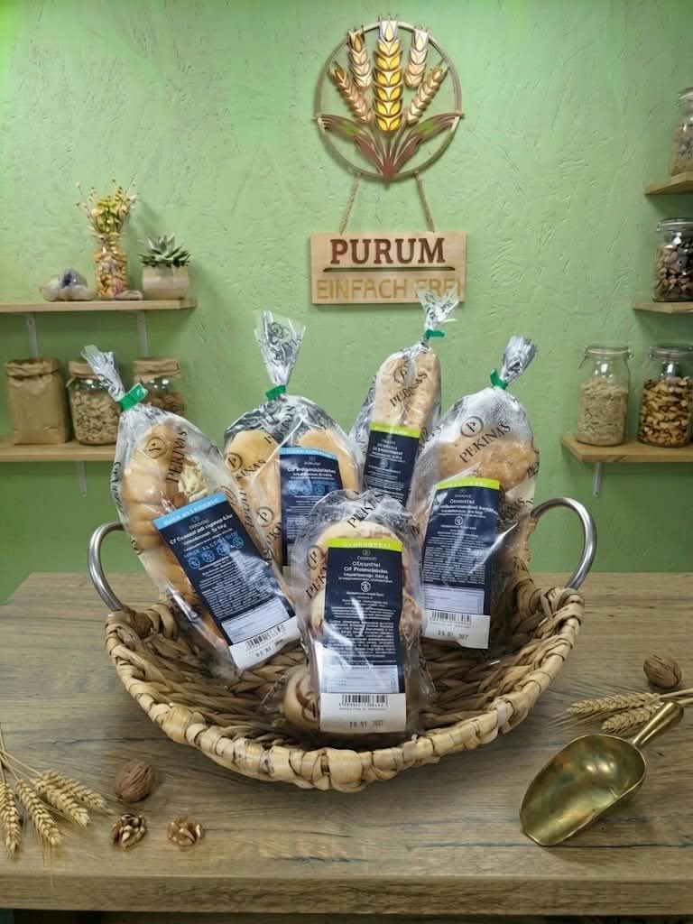 Frische Brotsorten im Korb vor dem PURUM-Schild